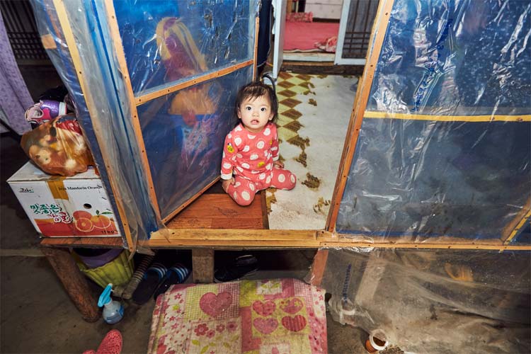 작은 집 마루에 앉아 있는 아이 사진